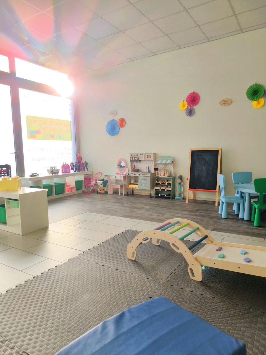 Sala gioco luminosa con angolo cucina e lavagna